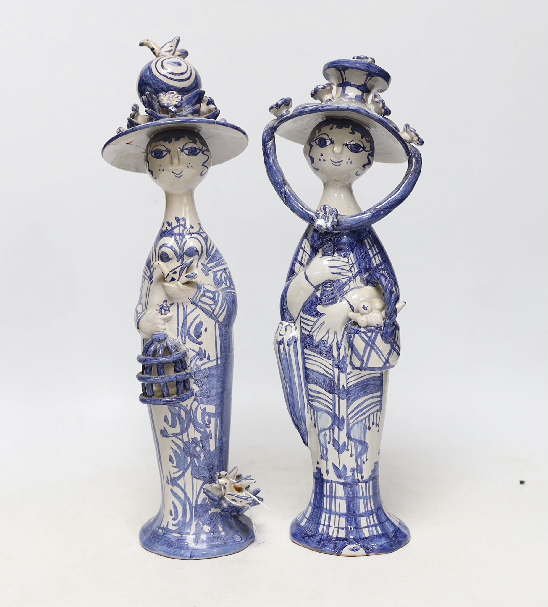Two Bjørn Wiinblad, Denmark, blue and white ceramic female figures with large hats, 34.5cm
